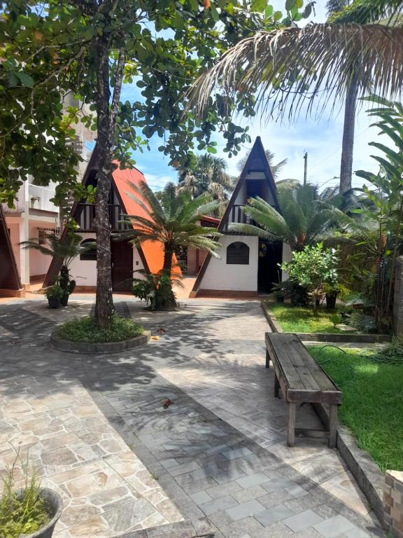 a wooden bench sitting in front of a house at Chalés Monções in Ubatuba