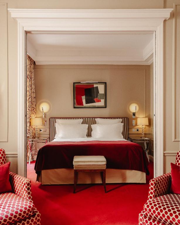 a bedroom with a large bed with a red carpet at Le Burgundy Paris in Paris