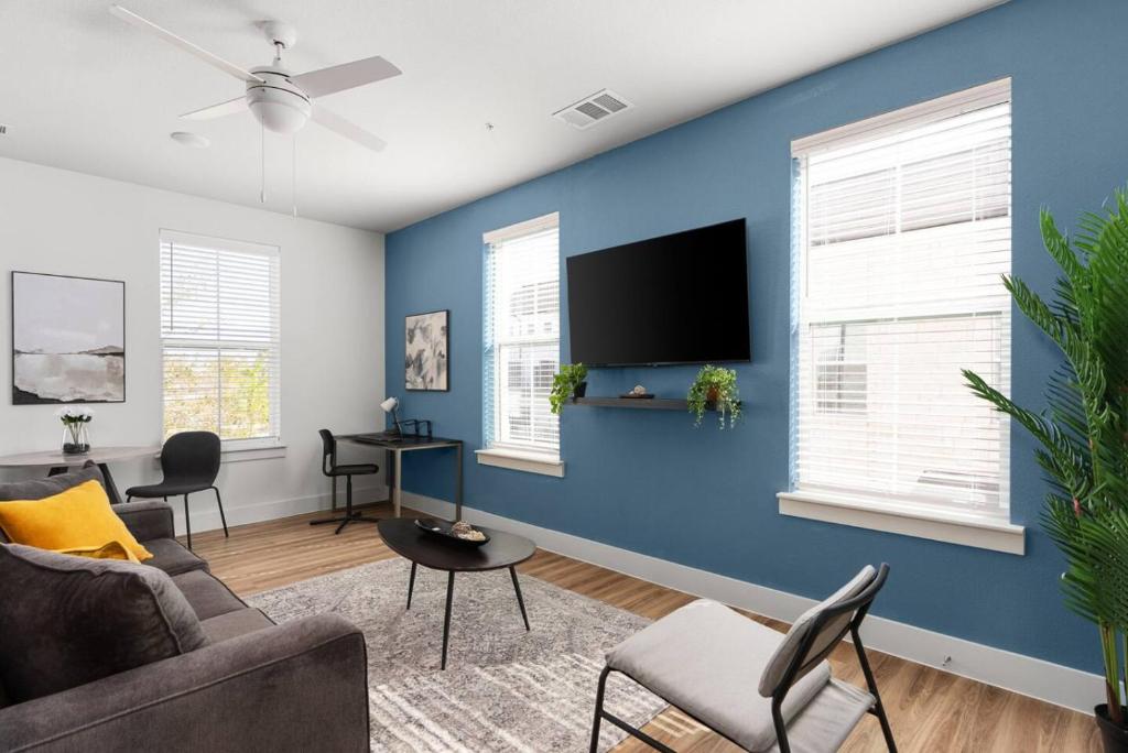 un soggiorno con parete blu e TV a schermo piatto di Modern Living 1B 1B Steps from Shops, Dining Fun a Pflugerville