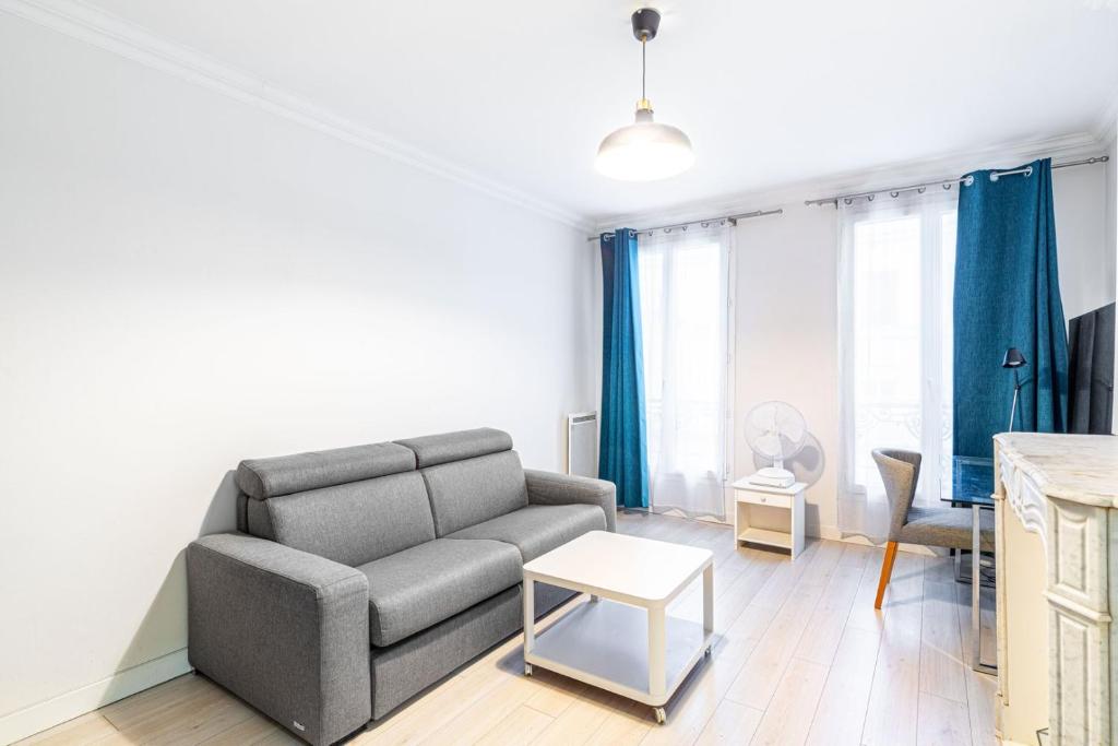 un salon avec un canapé et une table dans l'établissement GuestReady - Studio Parisien près des attractions, à Paris