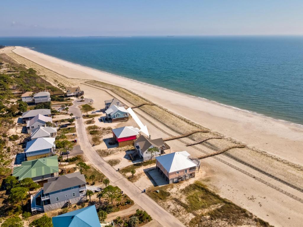 an aerial view of a beach with houses and the ocean at Pour House in Dauphin Island