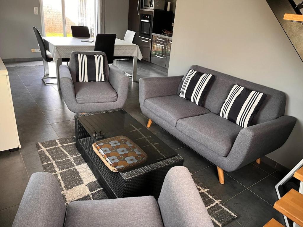 un salon avec deux canapés et une table dans l'établissement Maison de la plage avec Piscine - Breizh Location, au Guilvinec