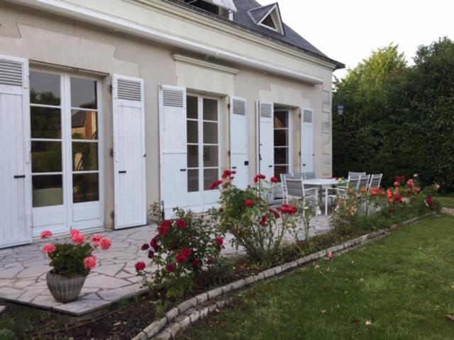 une maison avec une terrasse fleurie dans la cour dans l'établissement Brémailles41, à Onzain