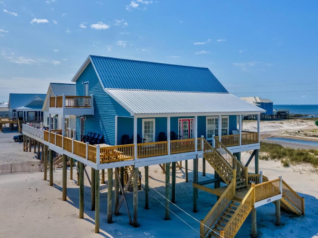 una casa azul en un muelle en la playa en Crew Rest, en Dauphin Island