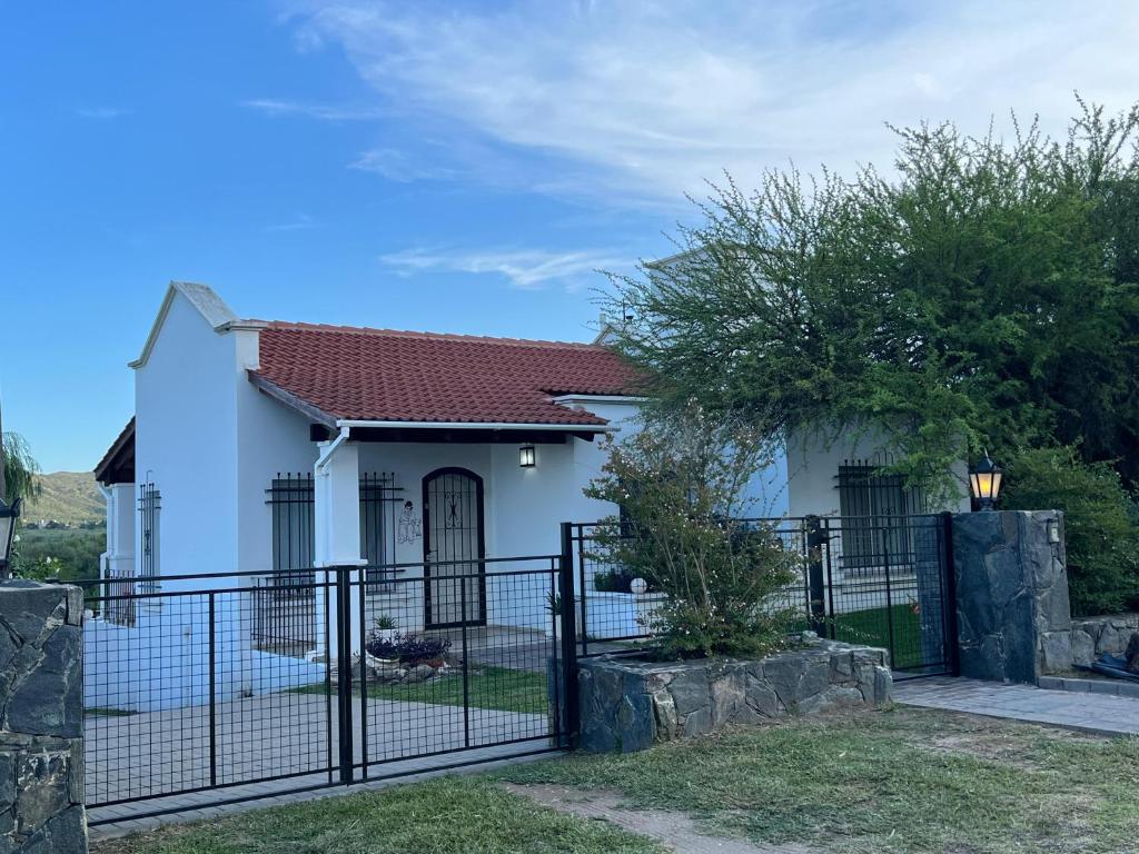 a small white house with a black fence at Casa en Lomas del Rey - Mayu Sumaj in San Antonio de Arredondo