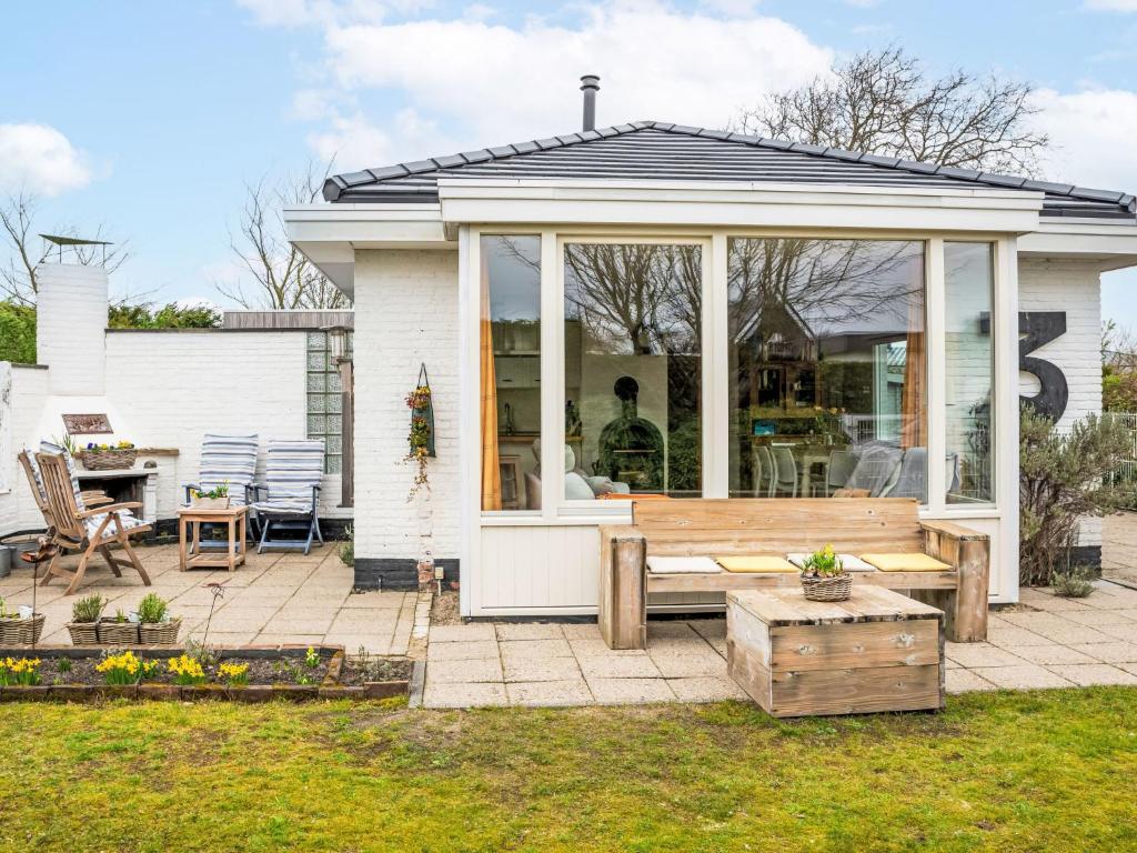 a screened in porch with a bench and a table at Holiday Home Horizon by the Sea by Interhome in Renesse