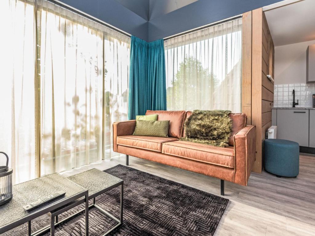 a living room with a brown couch and large windows at Apartment Renesse Bomont Sauna by Interhome in Renesse