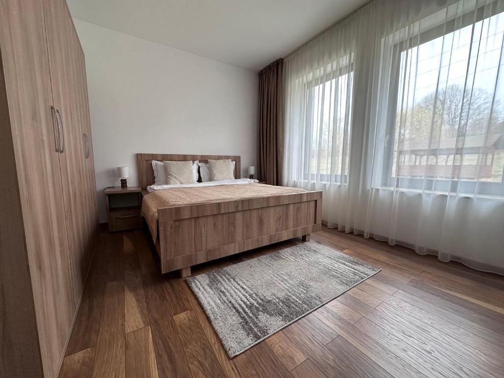 Tohanu NouにあるEdanApartmentsのベッドと大きな窓のある寝室