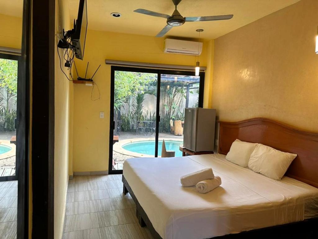 a bedroom with a bed with a ceiling fan at Casa la Roca Valladolid in Valladolid