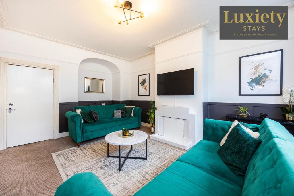 a living room with blue couches and a tv at Gorgeous & Stylish 3BR Home HIGH STREET LOCATION by Luxiety Stays Serviced Accommodation in Chelmsford