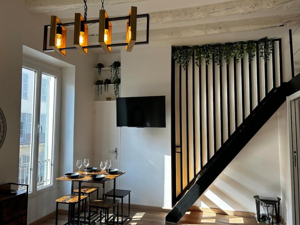 une salle à manger avec une table et un escalier dans l'établissement Cosy Studio Climatisé en plein cœur de Nice, à Nice