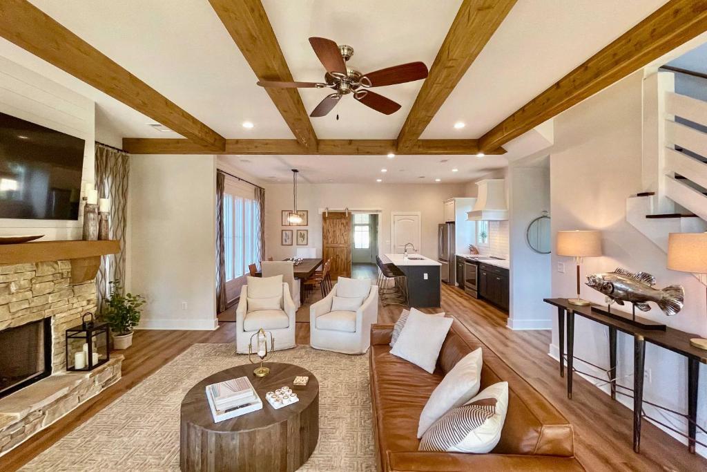a living room with a ceiling fan and a fireplace at Luxe Lakefront Getaway with Porch and Water View! in Dadeville