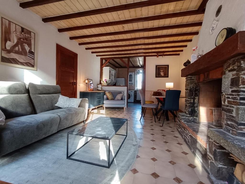 un salon avec un canapé et une cheminée dans l'établissement T3 Bagneres de Luchon , St Mamet, à Saint-Mamet