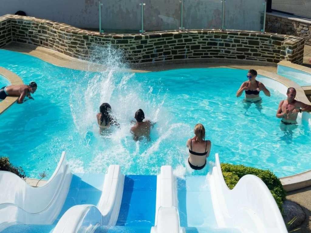 a group of people playing in a swimming pool at ZEcamping 4 étoiles animé parc aquatique pet friendly sauna in Saint-Lunaire