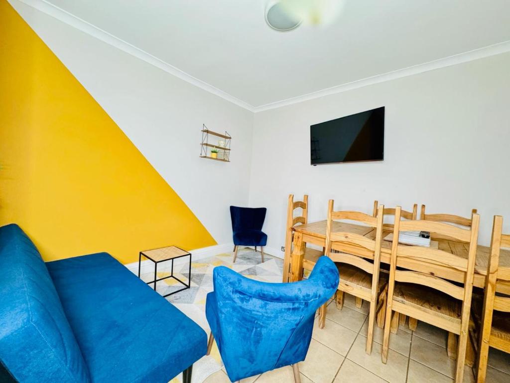 un salon avec un canapé bleu et une table dans l'établissement 4 Double Bed home in Newmarket - Tattersalls, à Newmarket