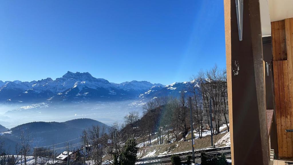 a view of a snowy mountain range from a window at sport et repos à Leysin CH in Leysin