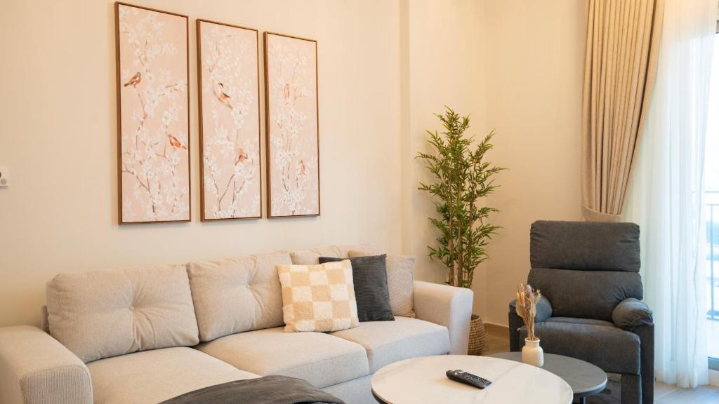 un salon avec un canapé et deux chaises dans l'établissement Cozy 1br With Stunning Seaworld Views!, à Abu Dhabi