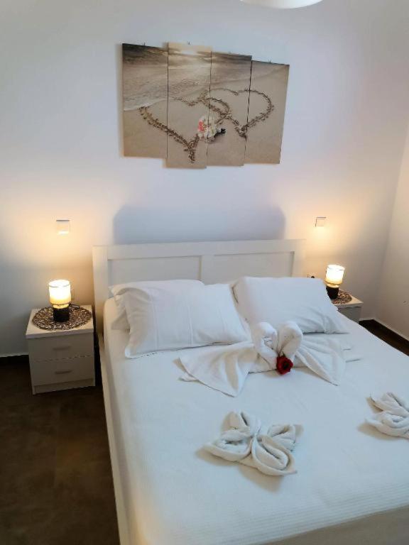 a white bed with two white towels on it at Sweet Home Nikorenia 1 in Krotiri