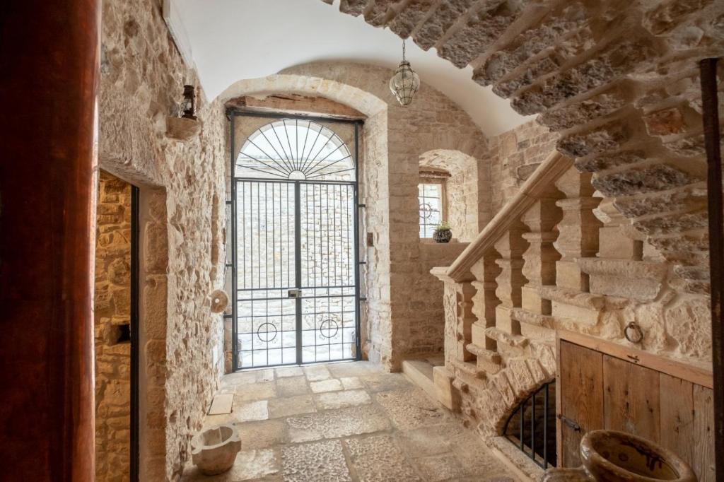 a hallway with a large glass door in a stone building at Palazzo Rizzi Dimora dei Templari in Bitetto