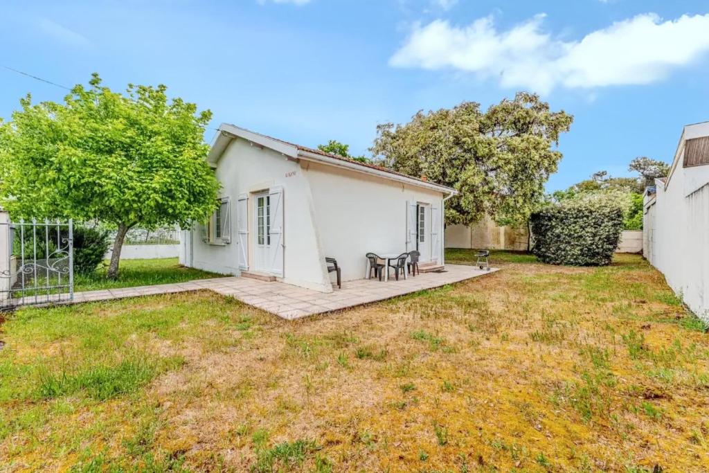 a small white house with a yard at Maison charmante à Soulac-sur-Mer avec jardin clôturé in Soulac-sur-Mer
