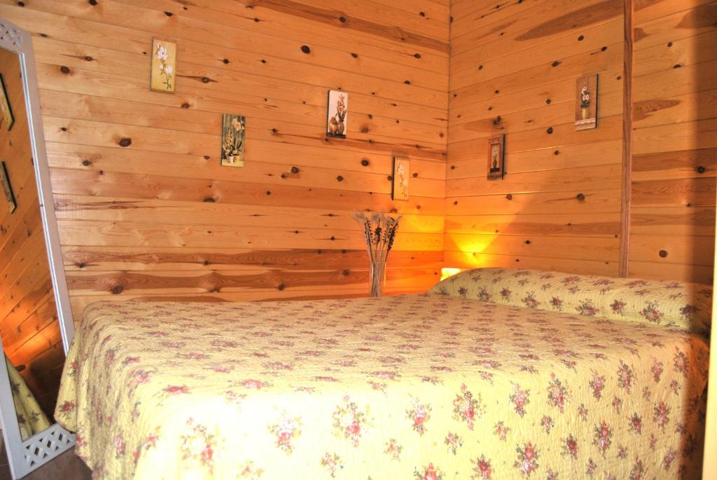 - une chambre avec un lit dans une pièce dotée de murs en bois dans l'établissement Spa Natura Resort, à Peñíscola