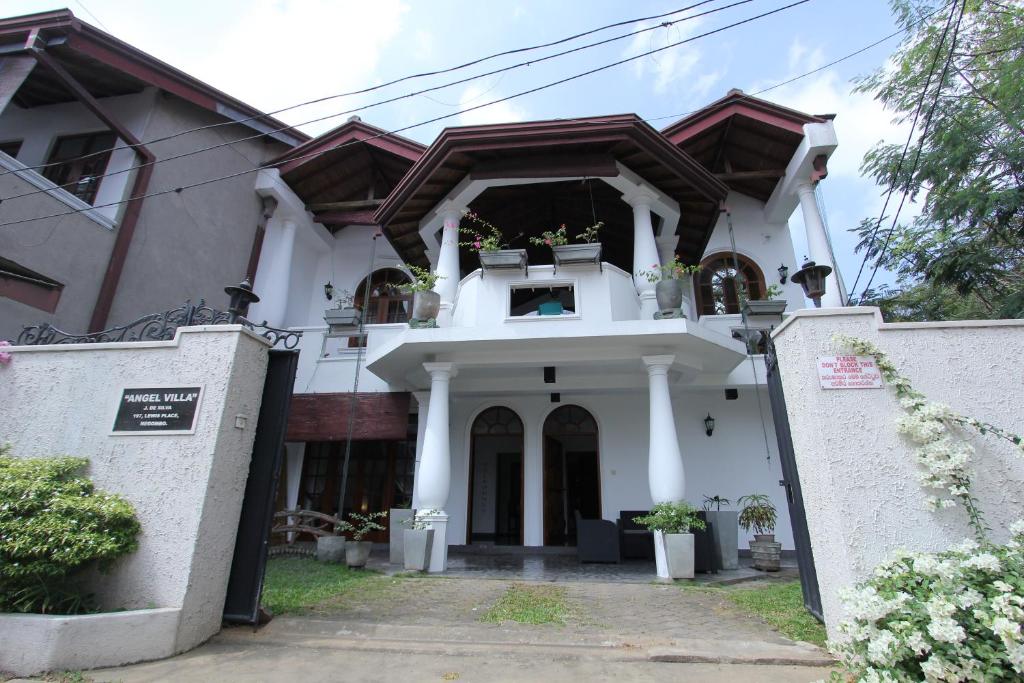 una casa bianca con un cancello davanti di Angel villa a Negombo