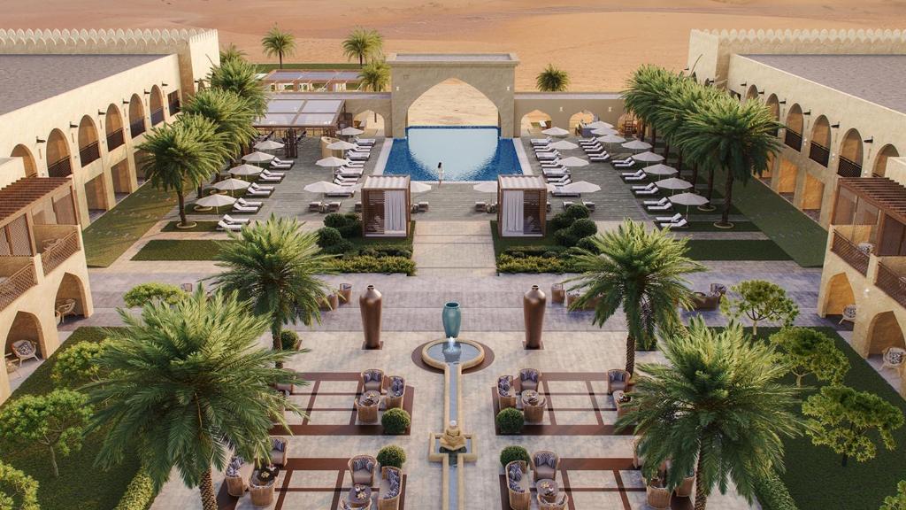an overhead view of a resort with a pool and palm trees at Aldhafra Resort, Vignette Collection by IHG in Madīnat Zāyid