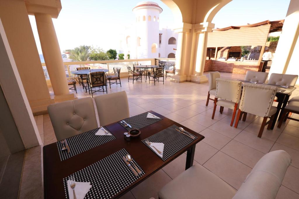 un restaurant avec une table et des chaises et un phare dans l'établissement Continental Plaza Beach Resort, à Charm el-Cheikh