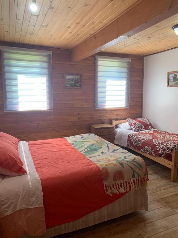 Ένα ή περισσότερα κρεβάτια σε δωμάτιο στο Hostal Tour Pucon