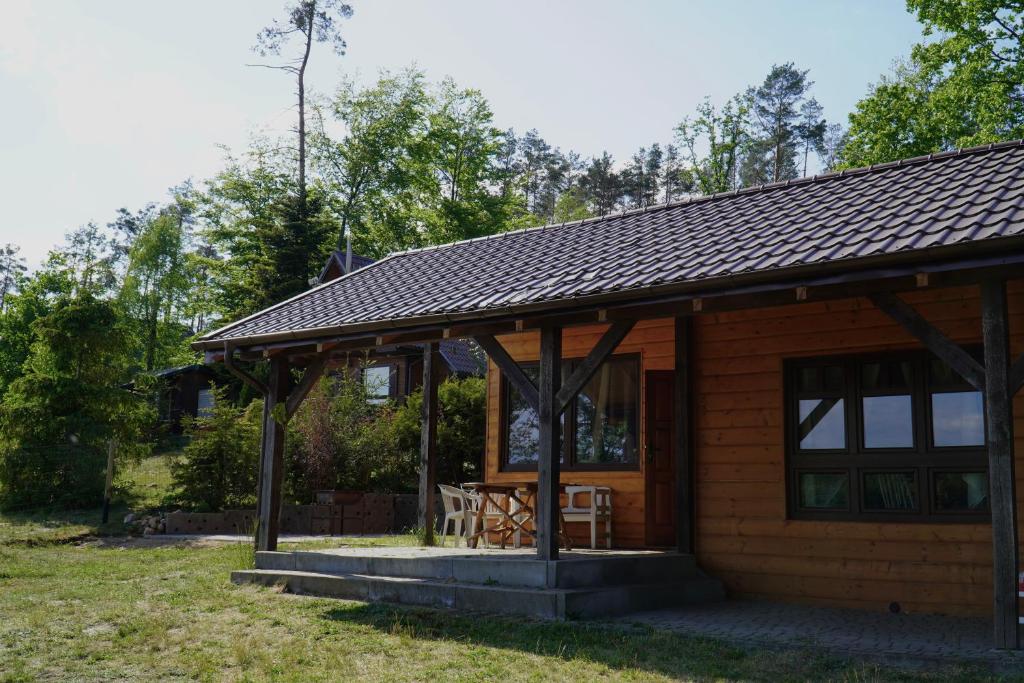 a log cabin with a porch and a table at Domki nad jeziorem Węgorzyno in Augustowo