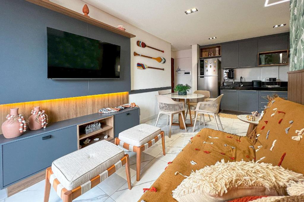 ein Wohnzimmer mit einem Sofa und einem Fernseher an der Wand in der Unterkunft Charmoso Bessa 200m da Praia 2 Quartos 5 Pessoas in Nossa Senhora do Livramento