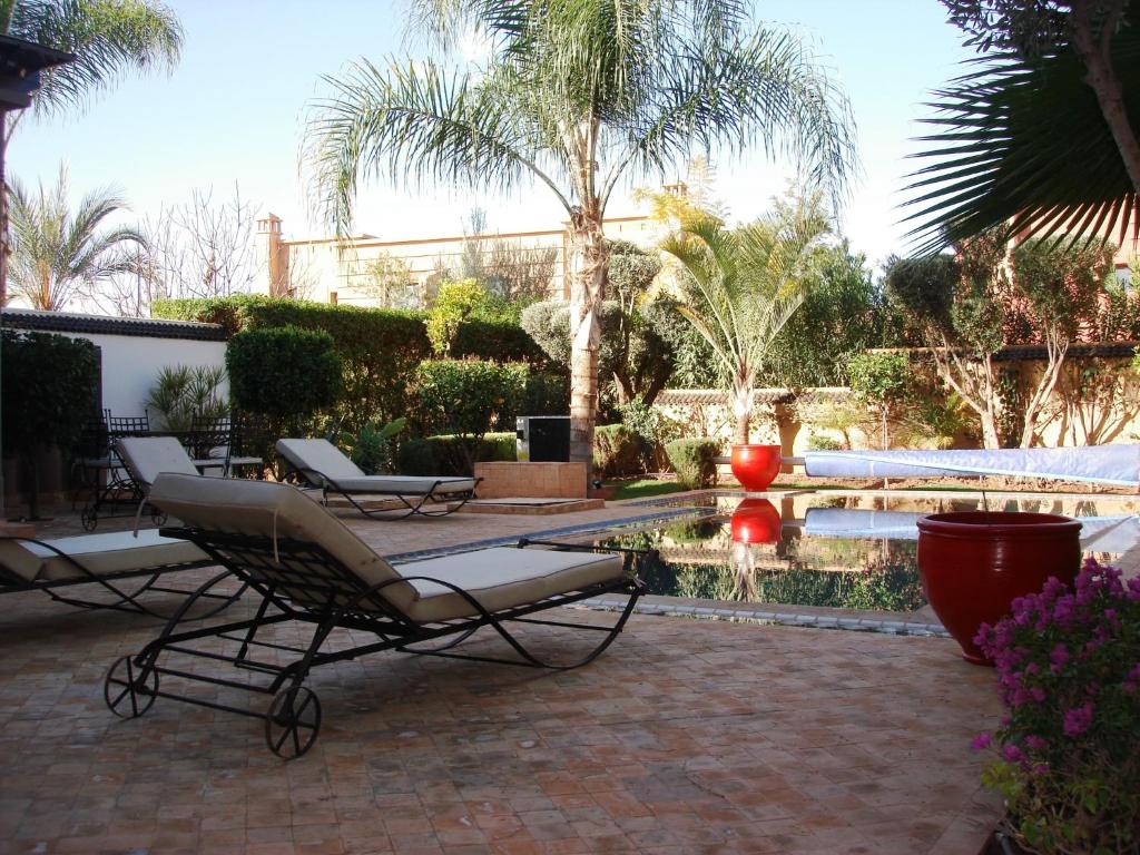 eine Terrasse mit Stühlen und einen Pool mit einem Brunnen in der Unterkunft Dar Carissa in Ala el Ma