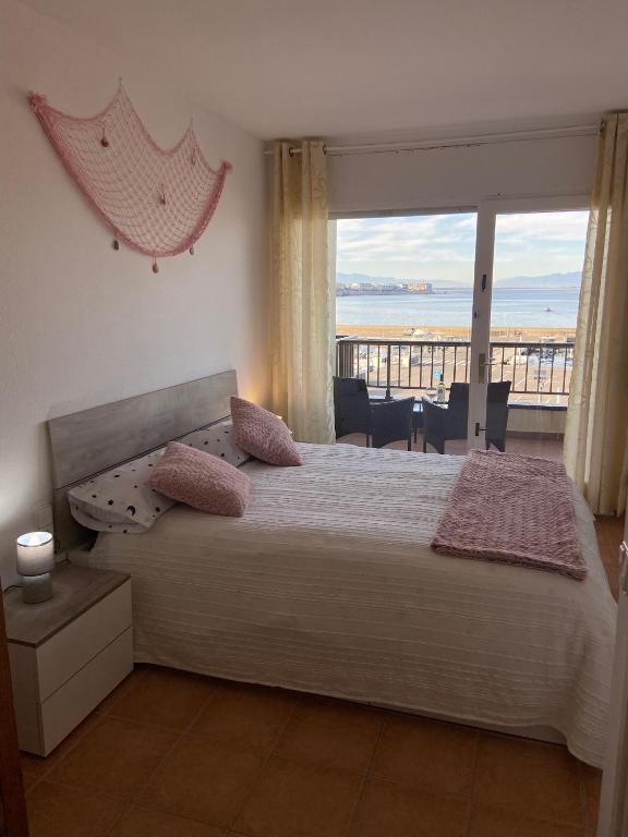 a bedroom with a bed with a view of the ocean at Ca La Ona in L'Escala