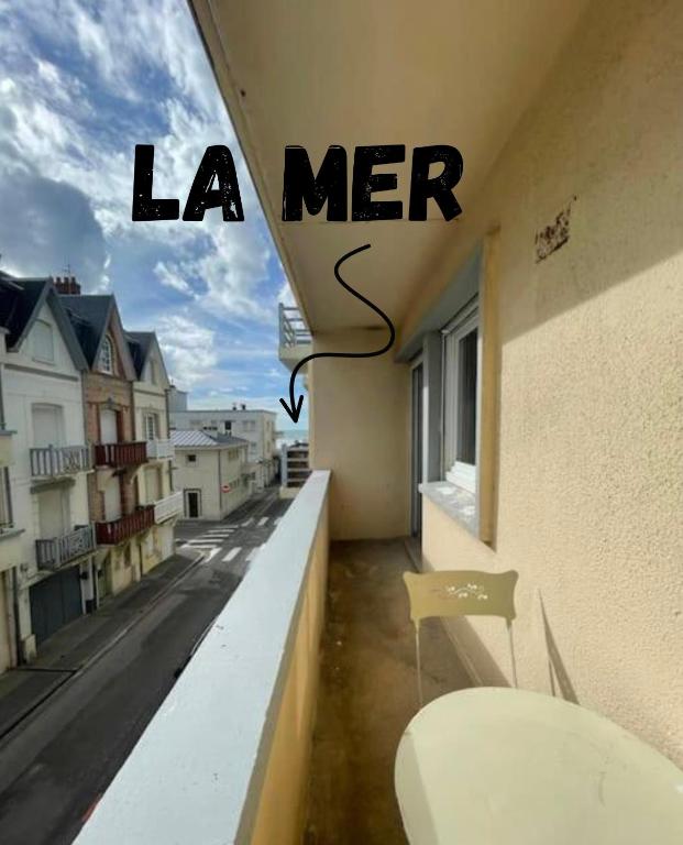 un balcon avec une table et une vue sur une ville dans l'établissement Balcon - Vue latérale mer - 4 à 6 pers - Lumineux, à Berck-sur-Mer