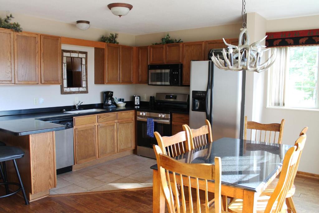 una cocina con mesa de comedor y refrigerador en Unit126, 2 bedroom Lower Duck Lake Condo, en Eagle River