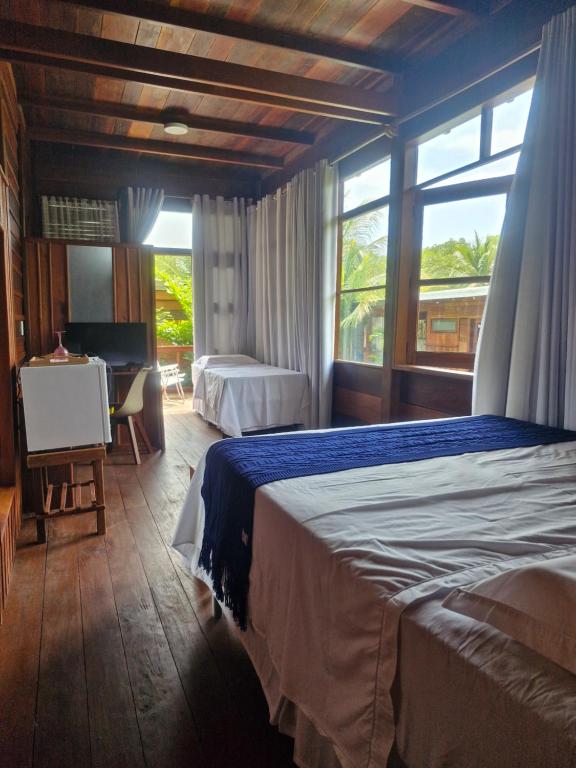 Chalés Mãe Natureza - Reserva do Matuto في فيرا كروز دو إيتاباريكا: غرفة نوم بها سرير ومكتب ونافذة