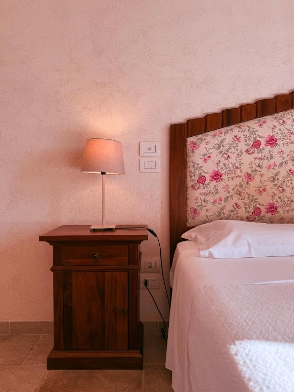 sypialnia z łóżkiem i stołem z lampką w obiekcie Masseria Sacramento w mieście Palagianello