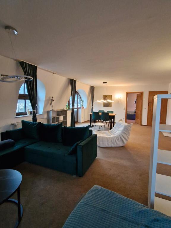 una sala de estar con un sofá y una mesa en Stadtvilla Apartment mit Schlossblick, en Heidenheim an der Brenz