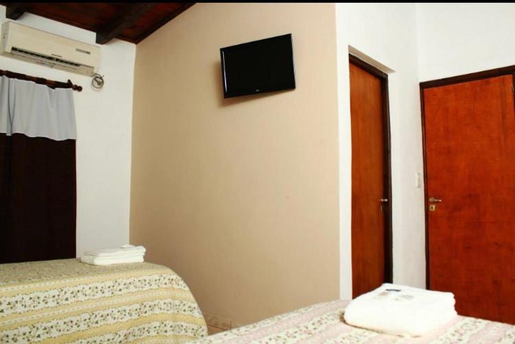 a room with two beds and a tv on the wall at Litoral Apart in Eldorado