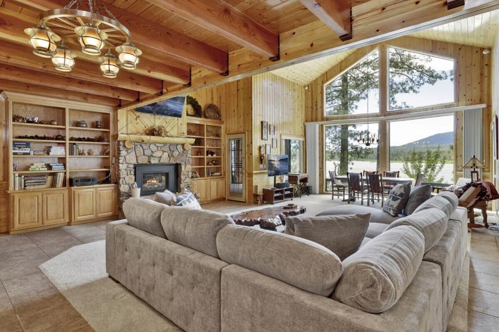 Una gran sala de estar con un gran sofá y una chimenea. en Eagle Point Lake House by Big Bear Vacations, en Big Bear Lake