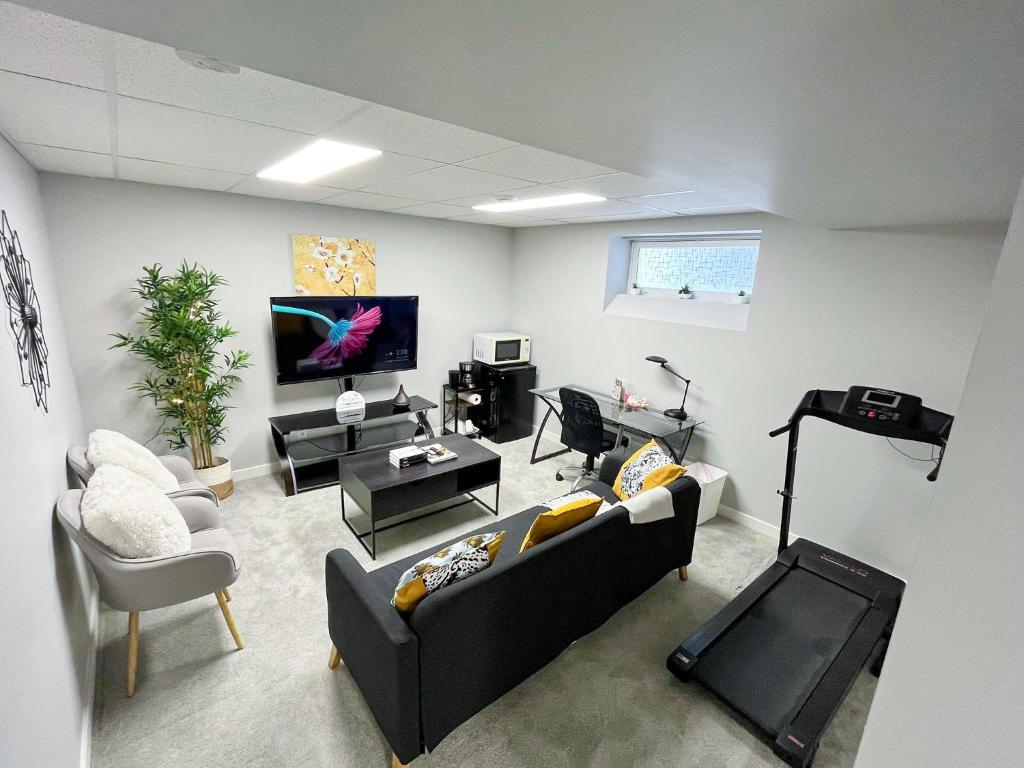 a living room with a couch and a tv at Modern Basement Suite with Comforts in Winnipeg