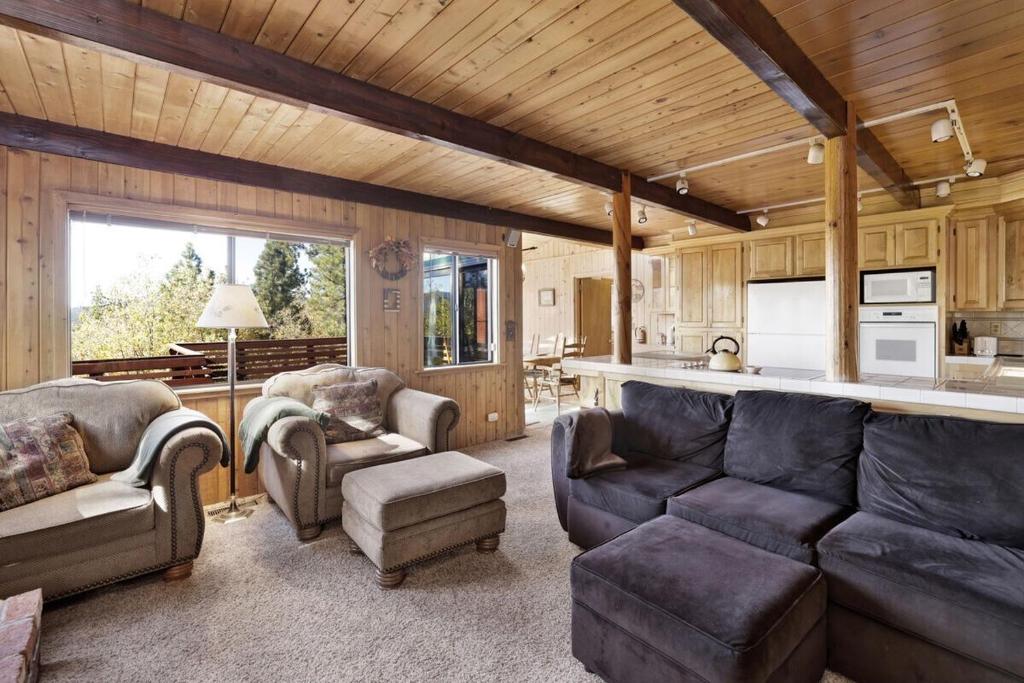 Una sala de estar con un sofá y sillas y una cocina. en Mountain Hideaway on Maryland by Big Bear Vacations, en Big Bear Lake