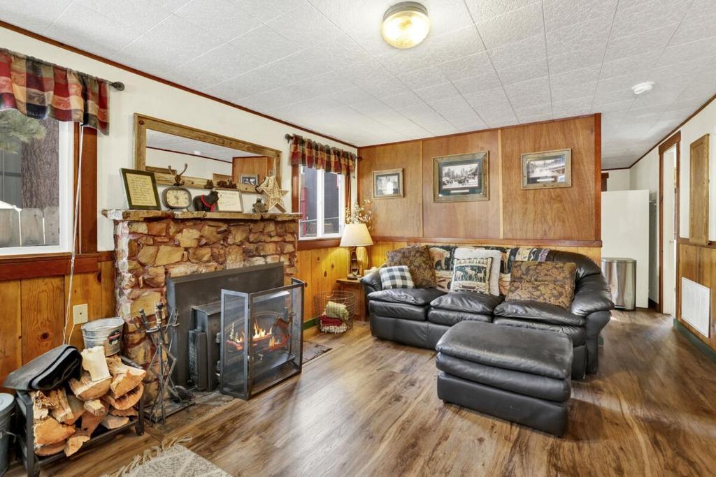 een woonkamer met een bank en een open haard bij Green Squirrel Chateau by Big Bear Vacations in Big Bear Lake