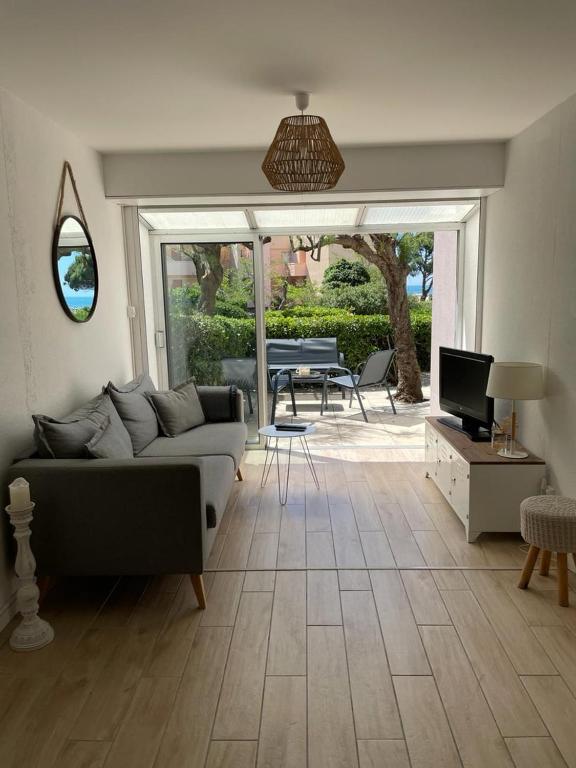 un salon avec un canapé et une table dans l'établissement Le Cosy - 50M des plages, à Sète