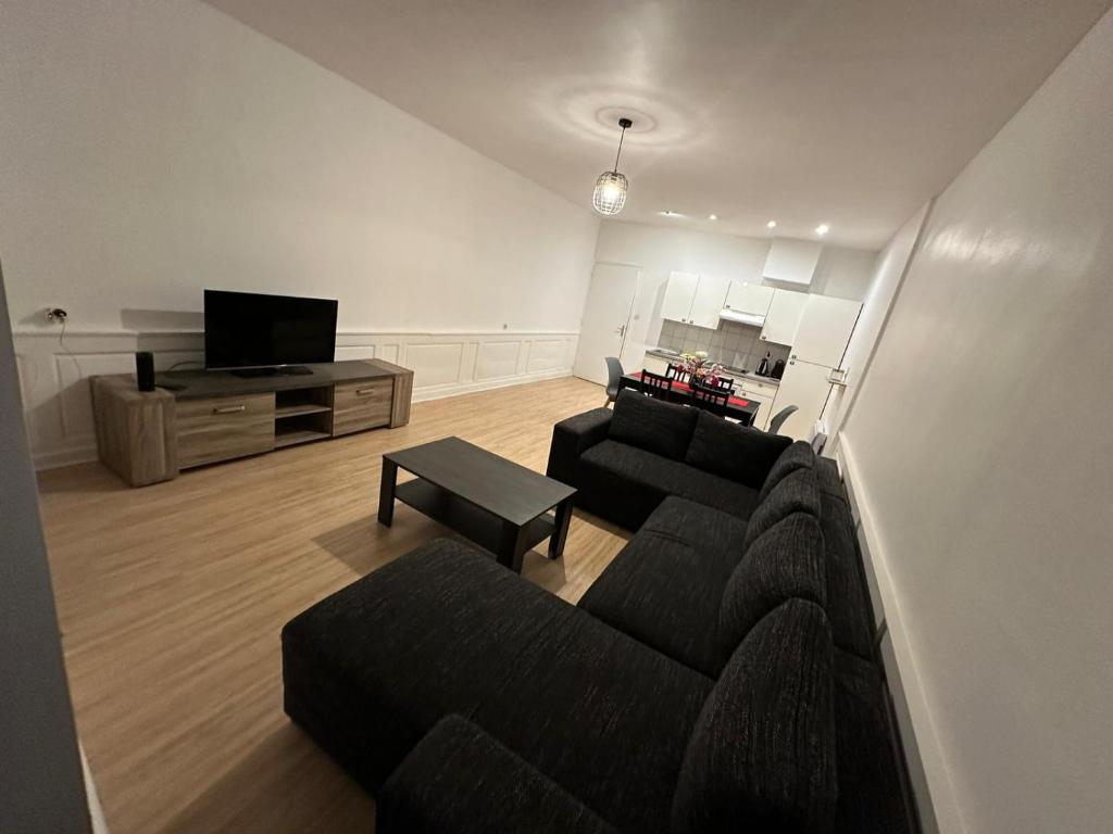 a living room with a couch and a tv at Appartement de 60 m2 au centre ville de morez in Morez