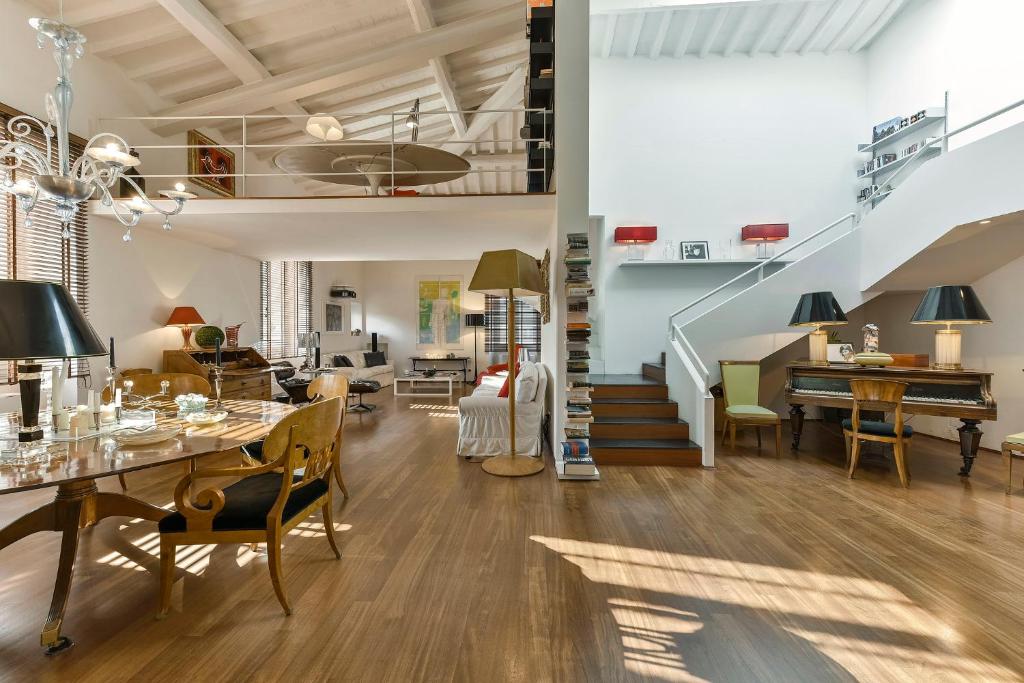un soggiorno con scala e una sala da pranzo di An amazing apartment in Oltrarno a Firenze