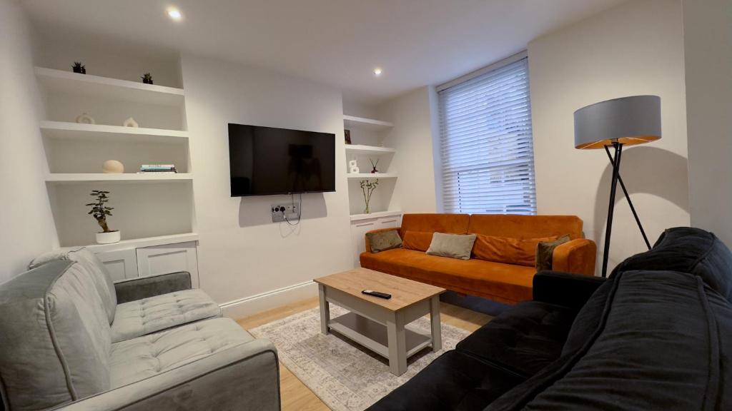 a living room with a couch and a tv at COSY Modern HOME Euston Fitzrovia in London