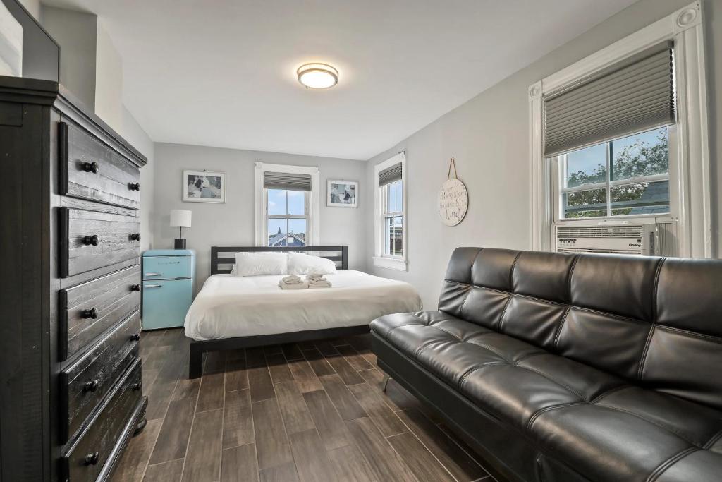 una camera con letto e divano in pelle di The Inn At Ocean Grove a Ocean Grove
