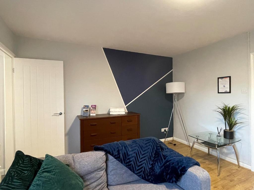 Una sala de estar con un sofá y una mesa de cristal. en Parkside Apartments Boston, en Boston