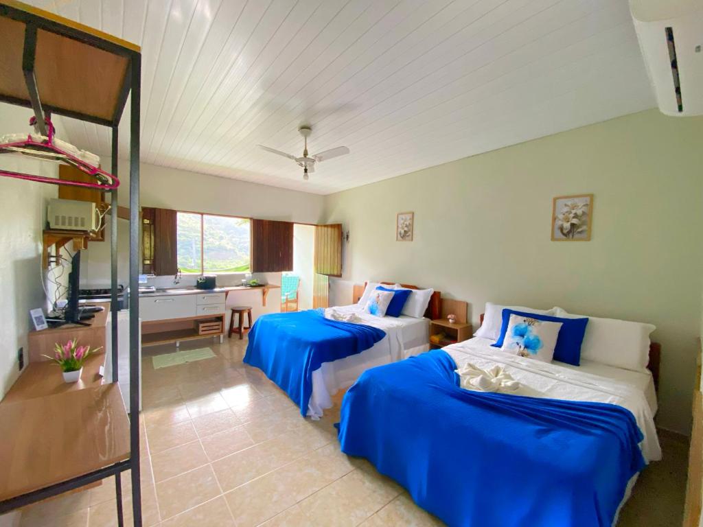 a hotel room with two beds and a bathroom at Aptos e Flats condomínio Pedra do Rodeadouro in Bonito
